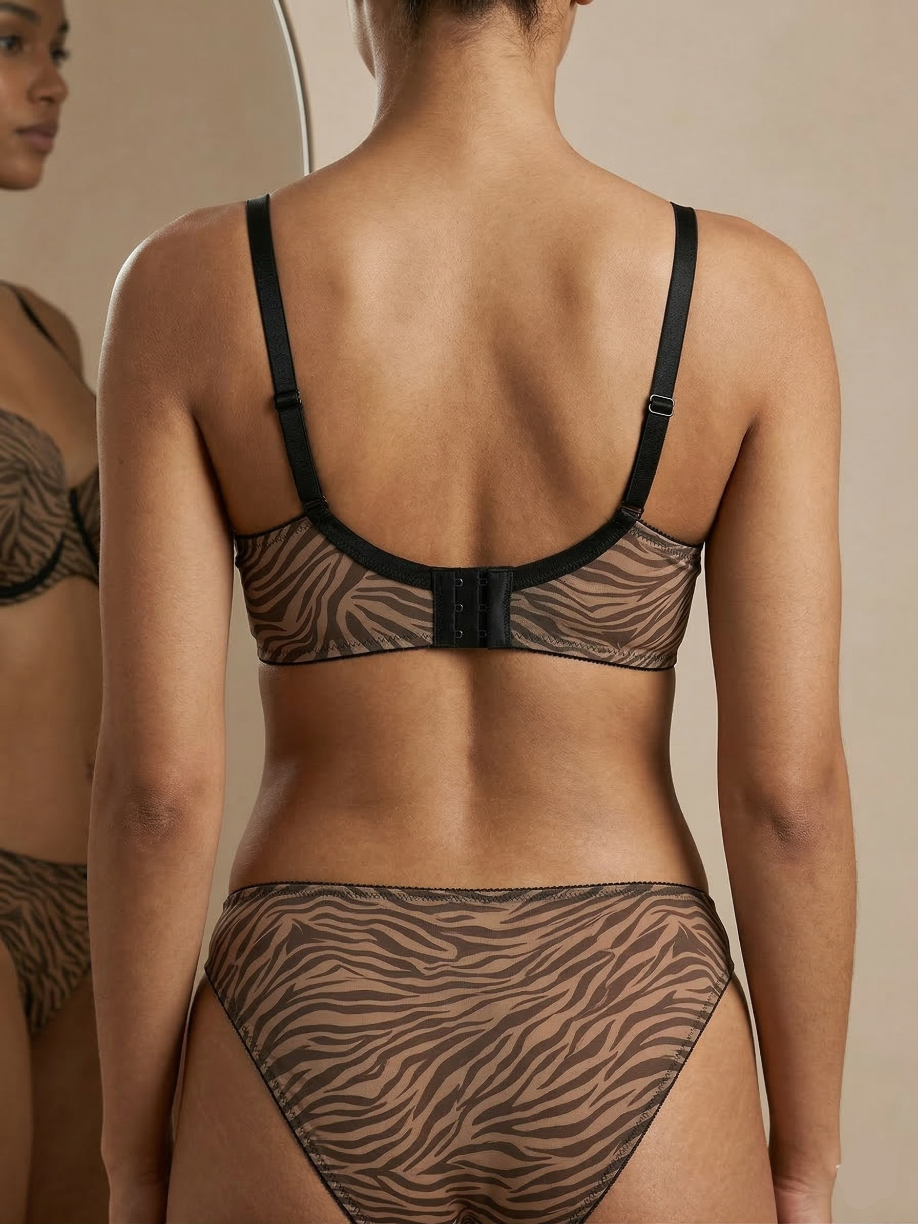 Person wearing a zebra print bra and panties set against a neutral background