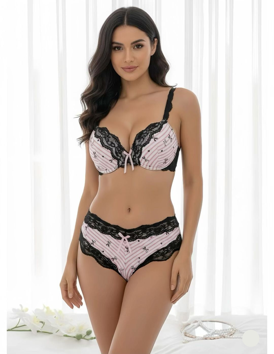 Woman wearing a black and white lace lingerie set against a white background